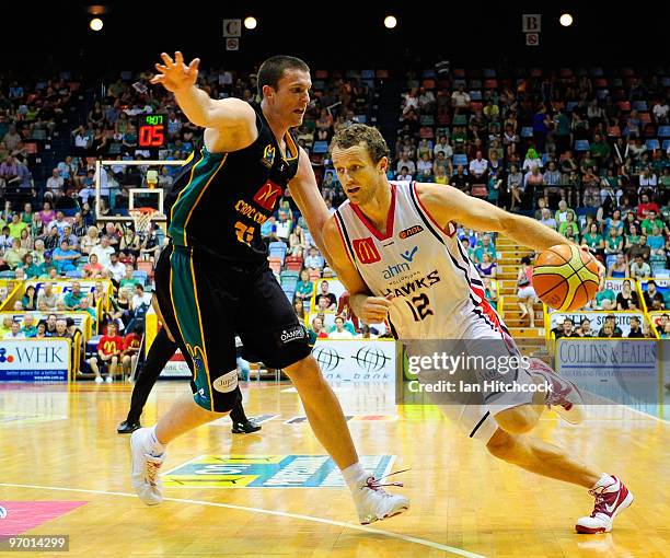 Glen Saville of the Hawks drives past Stephen Hoare of the Crocodiles during game two of the NBL semi final series between the Townsville Crocodiles...