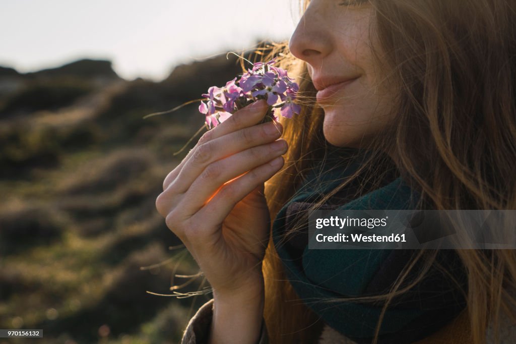 Woman enjoying fragrance of a flower