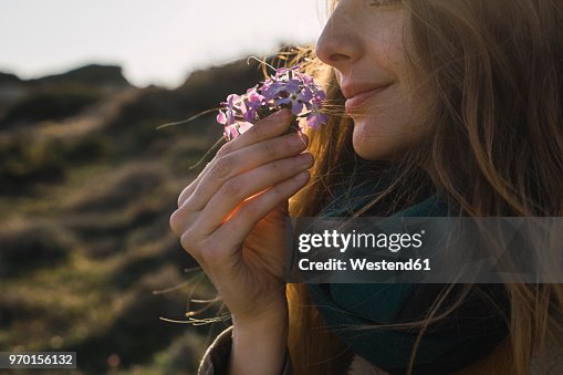 Woman enjoying fragrance of a flower Woman enjoying fragrance of a flower