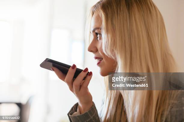 blond businesswoman talking into phone - woman talking cellphone stock-fotos und bilder