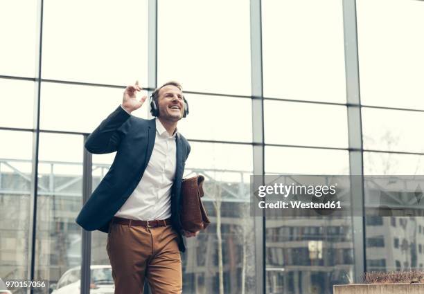 happy businessman listening to music with headphones - after work stock-fotos und bilder