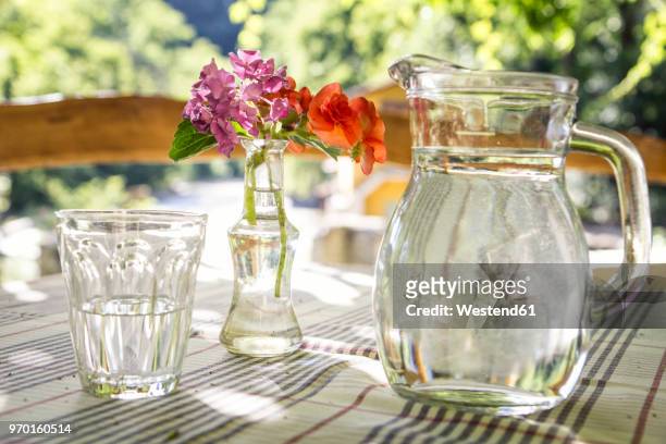glass jar and glass of water on table - karaffin bildbanksfoton och bilder
