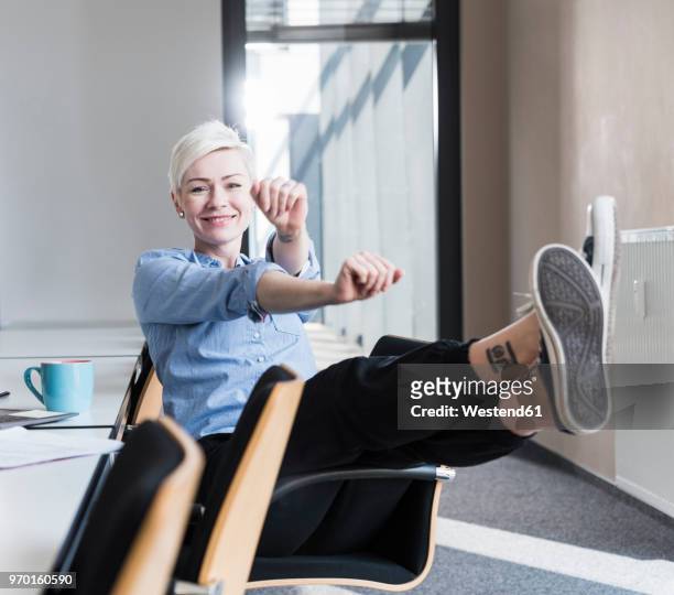 portrait of happy woman stretching on chair in office - leisure work coffee happy stockfoto's en -beelden