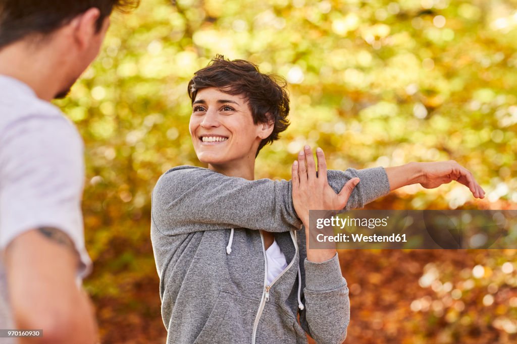 Couple stretching in forest