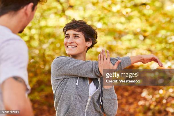 couple stretching in forest - munich autumn stock pictures, royalty-free photos & images