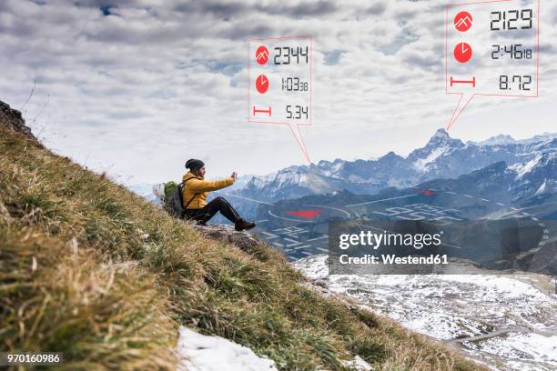 young man on a hiking trip with data emerging from smartphone - emerging from ground stock pictures, royalty-free photos & images