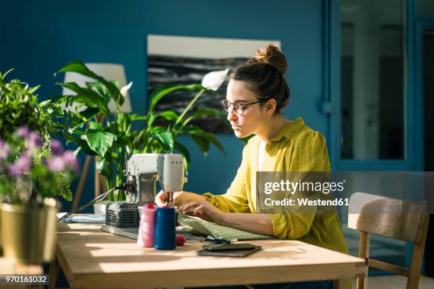 Fashion designer working with sewing machine in her studio