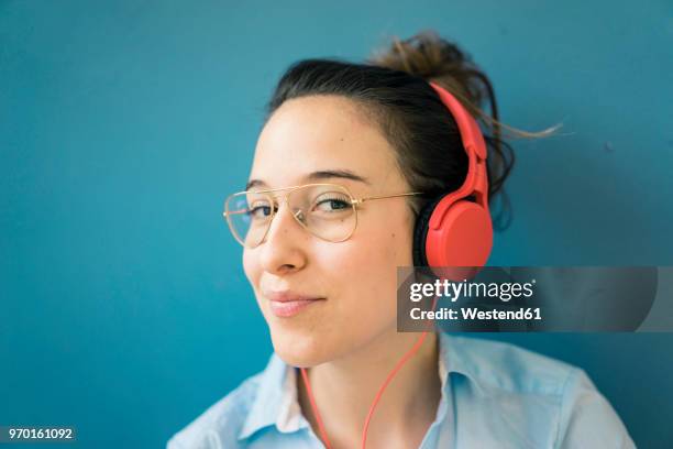 portrait of smirking woman listening music with headphones - sonrisa satisfecha fotografías e imágenes de stock