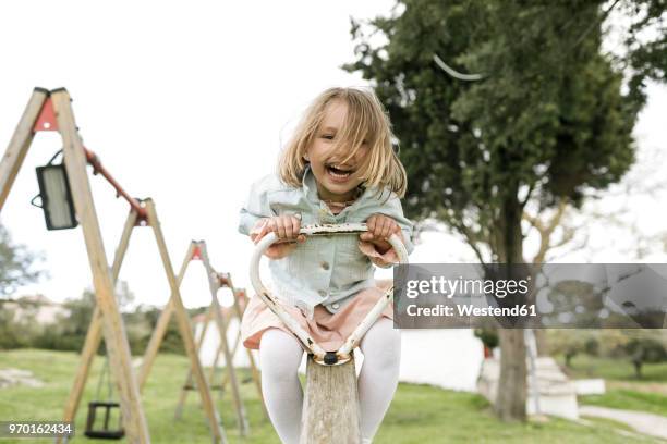 excited little girl having fun on a seesaw - see saw fotografías e imágenes de stock