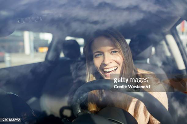 portrait of laughing young woman in car - rijden een motorvoertuig besturen stockfoto's en -beelden
