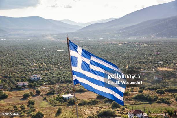 greece, peloponnese, arcadia, paralia astros, flag of greece, view to fertile plain of astros - arcadia greece stock pictures, royalty-free photos & images