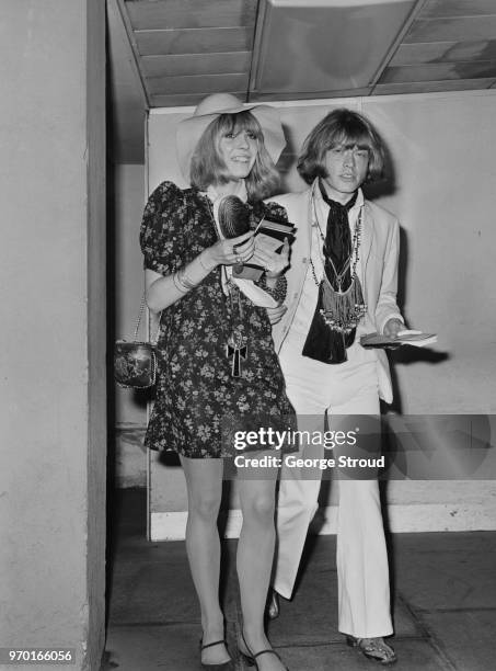 English musician Brian Jones of The Rolling Stones at Heathrow Airport, London, with his girlfriend, fashion model Suki Potier before a flight to...