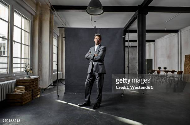 portrait of mature businessman in front of black backdrop in loft - black suit 個照片及圖片檔