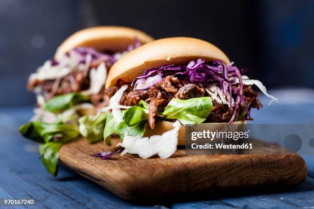 vegan jackfruit jurger with red cabbage, white cabbage, lamb's lettuce - healthy burger stock pictures, royalty-free photos & images