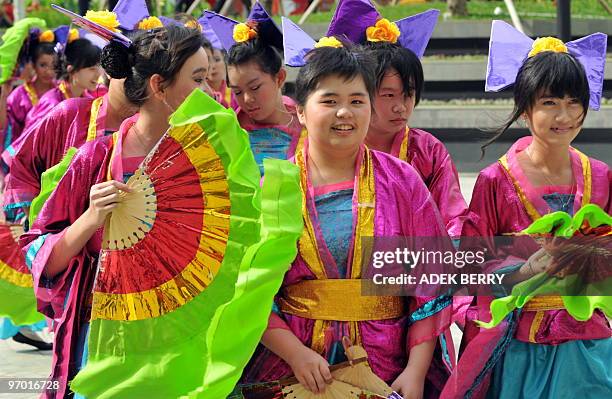 Indonesian students attend a ceremony presenting the 88 metres long dragon mascot made by 8,288 bottles of mineral water in Jakarta on February 12...