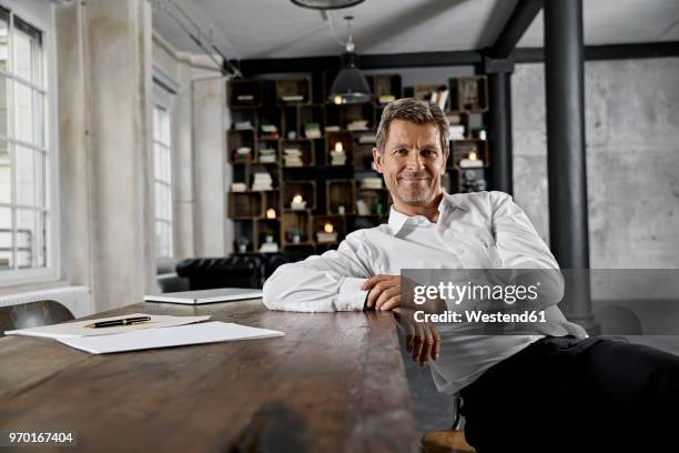 portrait of mature businessman in loft office - einzelner mann über 40 stock-fotos und bilder