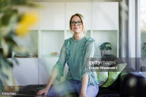 portrait of content businesswoman sitting on couch - businesswoman couch fotografías e imágenes de stock