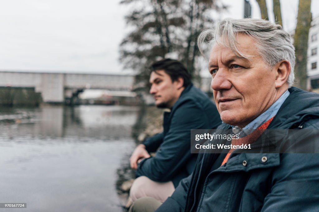 Senior man and young man at the riverside