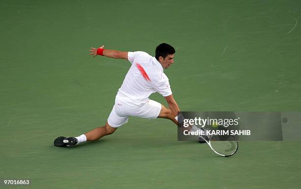 Serbia's Novak Djokovic returns the ball to his compatriot Viktor Troicki during their match in the second round of the ATP Dubai Open tennis...