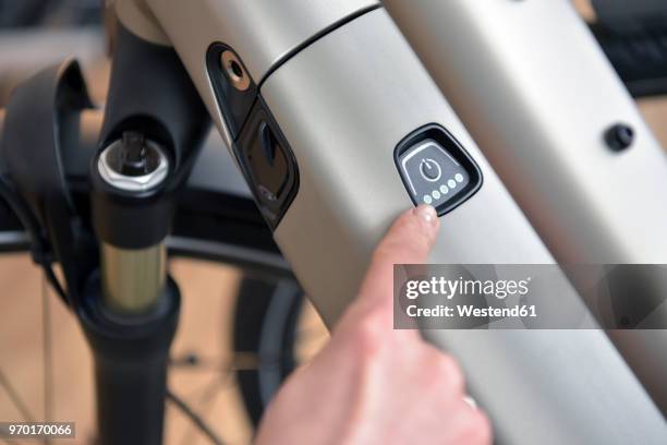 finger pointing on switch of an e-bike - e bike stock pictures, royalty-free photos & images