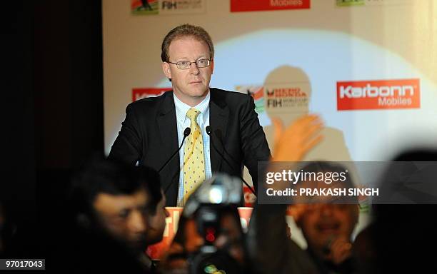 International Hockey Federation spokesman Arjen Meijer watches as protesting journalists shout and stop him from addressing a press conference in New...