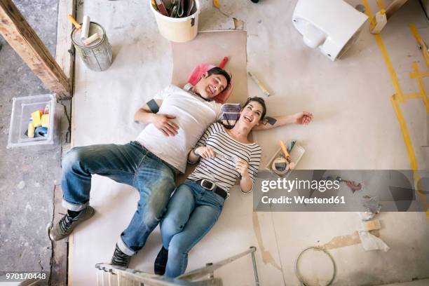 happy couple renovating new home, taking a break, daydreaming - flat renovation stock pictures, royalty-free photos & images