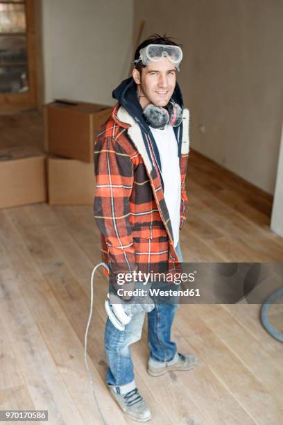 portrait of a handyman renovating flat - handyman smiling stock pictures, royalty-free photos & images