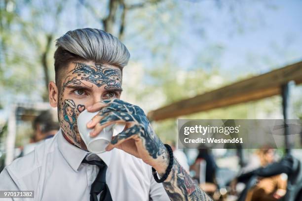 young businessman with tattooed face, drinking coffee - novi sad stock pictures, royalty-free photos & images