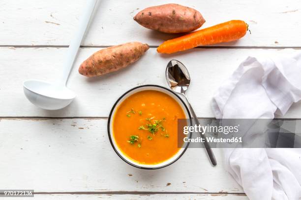 bowl of sweet potato carrot soup garnished with cress - soup bowl stock pictures, royalty-free photos & images