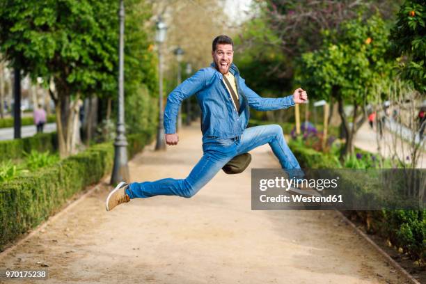 young man jumping - double denim stock pictures, royalty-free photos & images