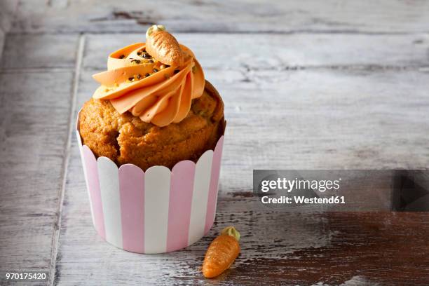 carrot cup cake garnished with cream topping, sugar granules and marzipan carrot - carrot cake stock pictures, royalty-free photos & images