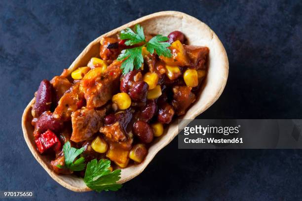 vegetarian chili with soy meat cut into strips in edible bowl - slätpersilja bildbanksfoton och bilder