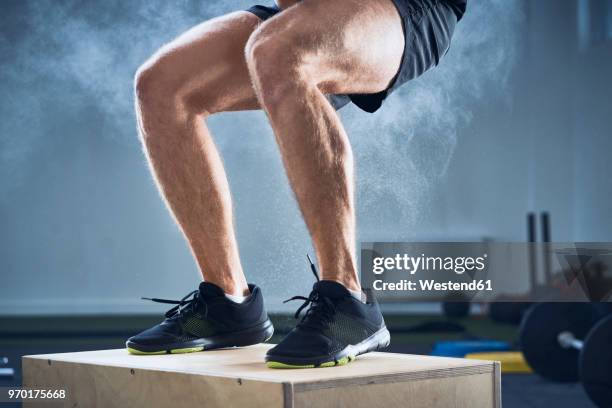 closeup of man doing box jump exercise at gym - parte inferior fotografías e imágenes de stock