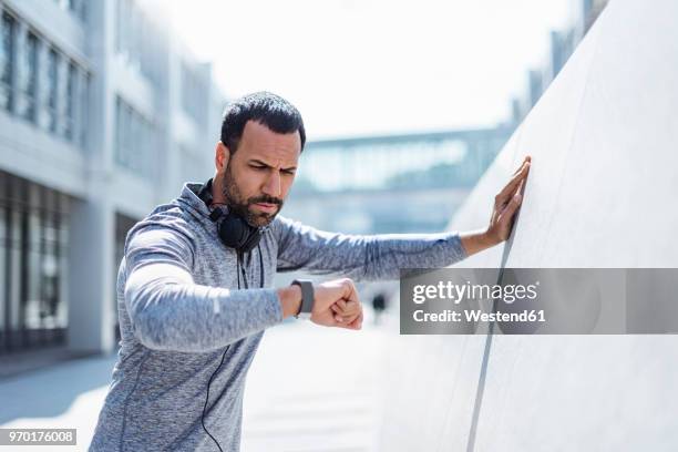 man having a break from exercising looking on smartwatch - checking the time stock pictures, royalty-free photos & images
