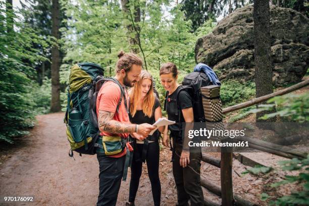 friends on a hiking trip reading map - elbsandsteingebirge stock-fotos und bilder