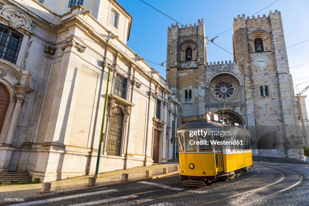 Portugal, Lisbon, typical yellow tram in front of the Cathedral