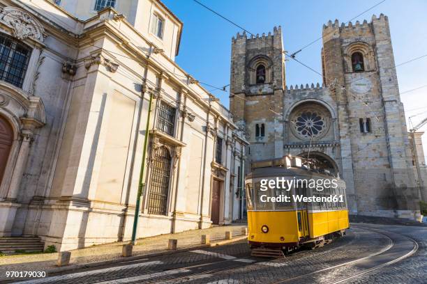 portugal, lisbon, typical yellow tram in front of the cathedral - lisbon stock pictures, royalty-free photos & images