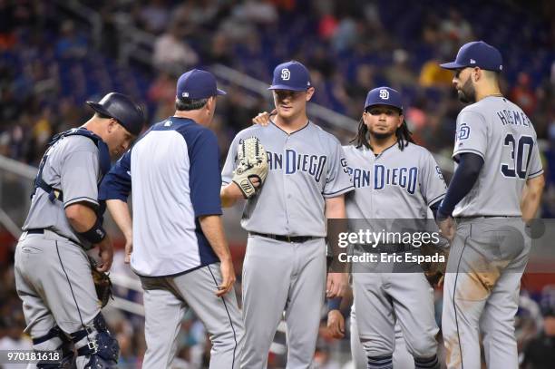 Pitching Coach Darren Balsley of the San Diego Padres talks with pitcher Eric Lauer during the sixth inning of the game against the Miami Marlins at...