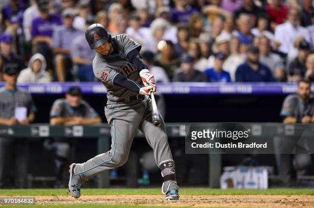 Chris Owings of the Arizona Diamondbacks hits an eighth inning sacrifice fly to score a run against the Colorado Rockies at Coors Field on June 8,...