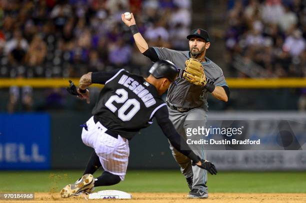 Daniel Descalso of the Arizona Diamondbacks throws to first base over Ian Desmond of the Colorado Rockies to complete a double play to end the eighth...