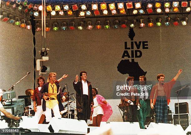 Steve Norman, Tony Hadley, John Keeble, Martin Kemp and Gary Kemp of Spandau Ballet wave farewell to the crowd after performing on stage at Live Aid...