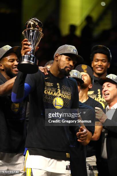 Kevin Durant of the Golden State Warriors celebrates with the NBA Finals MVP trophy after defeating the Cleveland Cavaliers during Game Four of the...