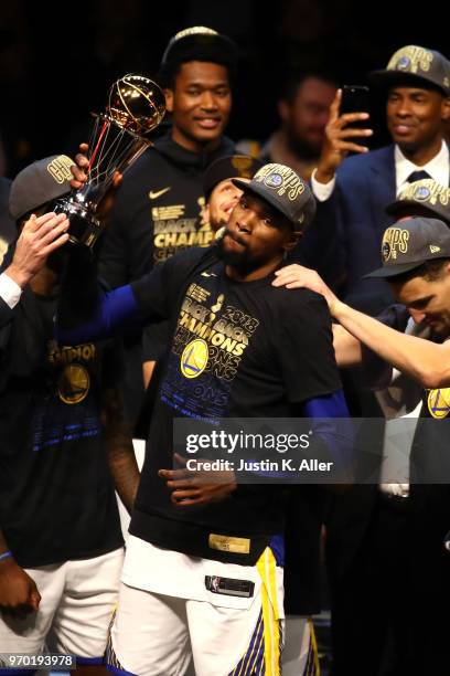 Kevin Durant of the Golden State Warriors celebrates with the NBA Finals MVP trophy after defeating the Cleveland Cavaliers during Game Four of the...