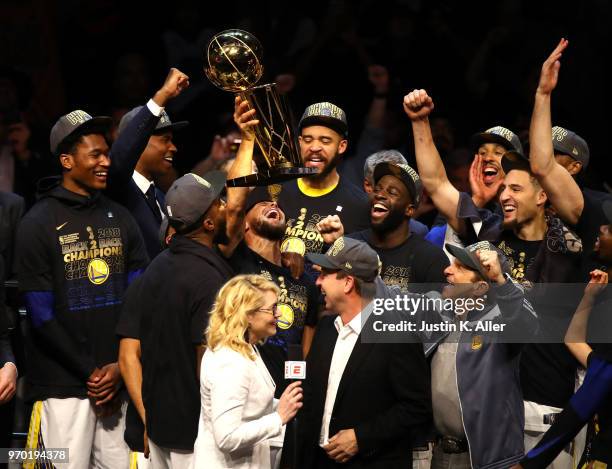 Stephen Curry of the Golden State Warriors celebrates with the Larry O'Brien Trophy after defeating the Cleveland Cavaliers during Game Four of the...