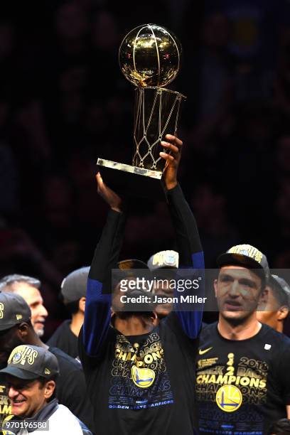Kevin Durant of the Golden State Warriors celebrates with the Larry O'Brien Trophy after defeating the Cleveland Cavaliers during Game Four of the...