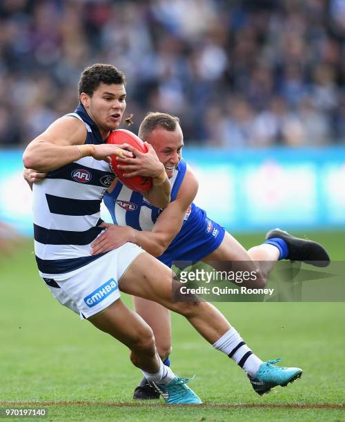 Brandan Parfitt of the Cats is tackled by Billy Hartung of the Kangaroos during the round 12 AFL match between the Geelong Cats and the North...