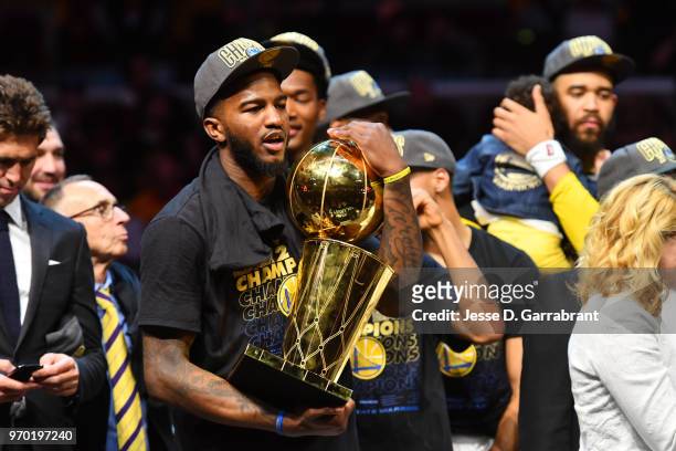 Jordan Bell of the Golden State Warriors holds the Larry O'Brien Championship trophy after defeating the Cleveland Cavaliers in Game Four of the 2018...