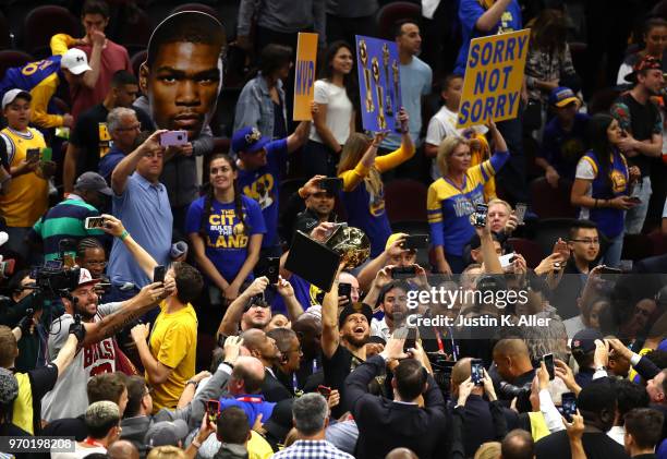 Stephen Curry of the Golden State Warriors celebrates with the Larry O'Brien Trophy after defeating the Cleveland Cavaliers during Game Four of the...