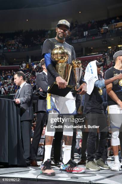 Kevin Durant of the Golden State Warriors holds the Larry O'Brien Championship Trophy and the Bill Russell NBA Finals MVP Trophy after Game Four of...