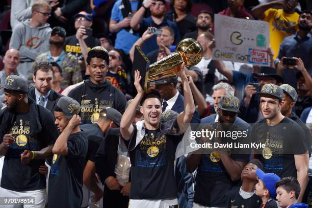 Klay Thompson of the Golden State Warriors celebrates after the game against the Cleveland Cavaliers while holding the Larry O'Brien NBA Championship...